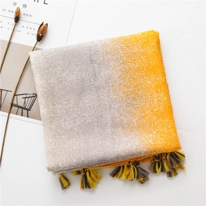 Detail of yellow and grey gradient scarf showing fine linen texture and tassel fringe