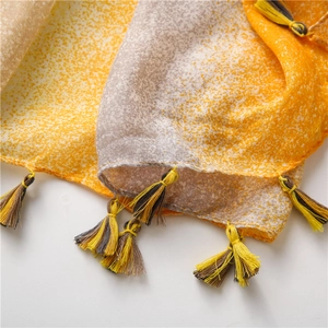Close-up of yellow and grey cotton scarf showing soft texture and handmade tassels