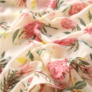 Detail of floral linen-feel scarf with pink protea prints on cream fabric texture