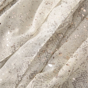 Gros plan d'un tissu imprimé serpent avec feuilles métallisées or rose et texture fine