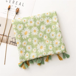 Détail d'une écharpe en coton vert clair à motif marguerite avec des franges tissées