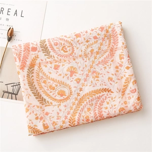 Détail d'une écharpe à motifs Paisley avec imprimés épis de blé dorés et fleur séchée