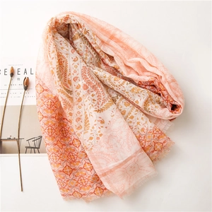 Détail de l'écharpe bohème à fleurs dorées avec dégradé de couleurs rose et orange chaud