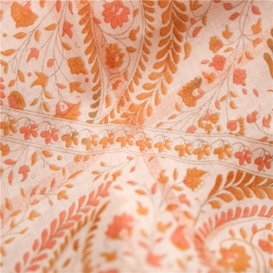 Détail macro du motif cachemire bohème et d'épis sur tissu de châle orange