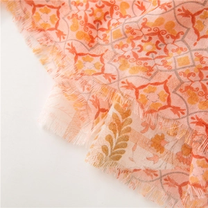 Gros plan d'une écharpe bohème montrant des franges douces et un motif floral complexe