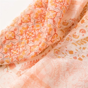 Détail macro d'un châle bohème avec motifs de blé doré et mandalas sur tissu léger