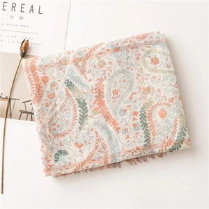 Détail d'une écharpe bohème à motifs paisley floraux orange avec des franges douces