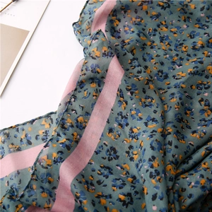 Detail showing the floral pattern and pink stripe edge of this thin cotton linen scarf