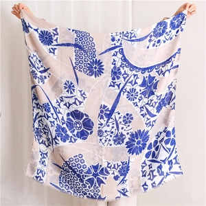 Close-up of vintage cotton-linen scarf with blue floral prints and fringed edges
