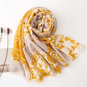 Close-up of printed cotton-linen scarf with floral patterns and frayed fringe edges