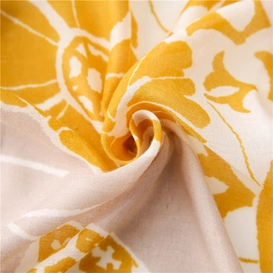 Close-up of yellow and beige floral printed linen-feel scarf fabric with elegant texture