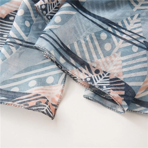 Gros plan détaillé du foulard à plumes montrant les coutures de qualité et la texture