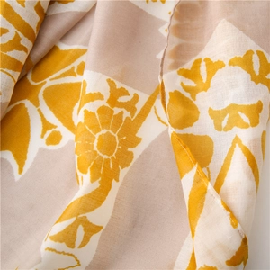 Close-up of lightweight floral print scarf with soft yellow and brown geometric patterns
