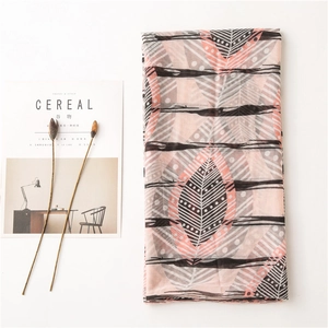 Détail d'écharpe rose et grise en coton et lin avec motifs plumes et fines rayures