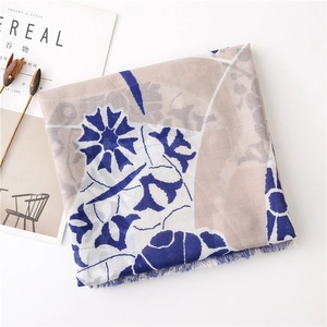 Detail of printed cotton linen scarf with blue floral patterns and tassel edges
