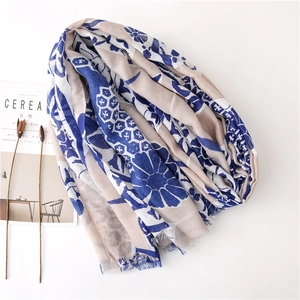 Detail of floral print scarf with soft tassels next to a minimalist lifestyle magazine
