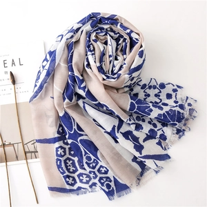 Close-up of printed linen scarf with blue abstract pattern and soft fringe edges