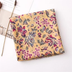 Detail of yellow floral cotton scarf with vintage pattern and soft frayed edges
