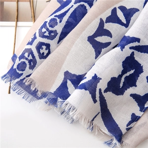 Detail of soft cotton linen scarf with geometric prints and natural frayed edges