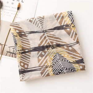 Détail d'une écharpe en lin doux avec motifs de plumes abstraits et accents jaunes
