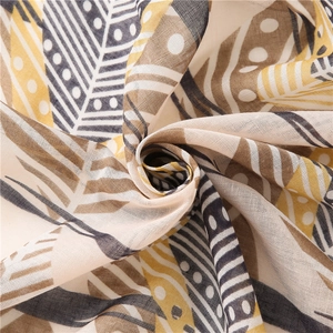 Gros plan d'une écharpe aux motifs de feuilles tropicales et texture plissée douce