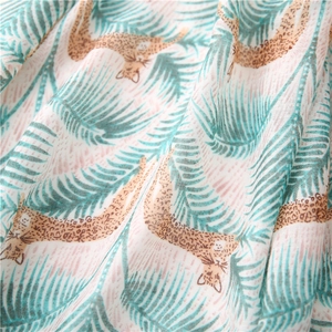 Macro shot of tropical palm leaves and leopard print on soft linen blend fabric