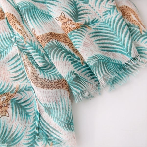 Close-up of leopard and palm leaf print fabric with delicate fringe edge detail