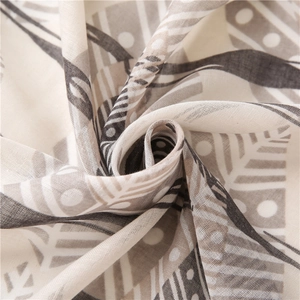 Détail macro du châle en coton et lin avec des motifs de plumes géométriques bruns
