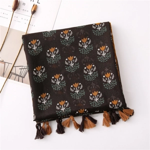 Detail of vintage floral print linen scarf with delicate brown tassels in a flat lay view