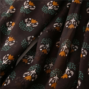 Detail of bohemian cotton linen scarf with brown floral prints and delicate fringe texture