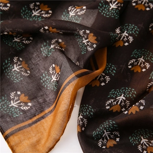 Detailed close-up of brown floral cotton linen scarf featuring bohemian tassels and patterns
