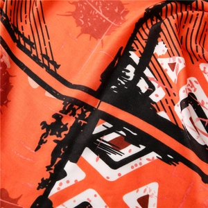 Gros plan du tissu d'écharpe orange avec des imprimés géométriques abstraits noir et blanc