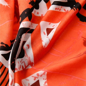 Détail macro du tissu d'écharpe orange avec des motifs géométriques abstraits vibrants