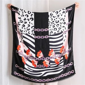 Close-up of zebra and leopard print scarf with chain patterns and orange floral details