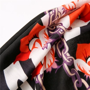 Close-up of lightweight scarf with vibrant floral, chain and zebra stripe patterns