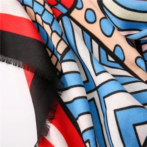 Close-up of abstract blue geometric print scarf with twill texture and fringed edges
