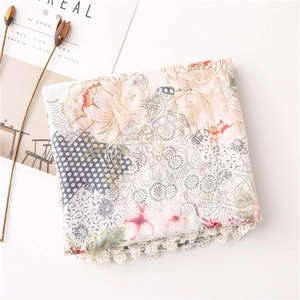 Detailed close-up of floral print scarf featuring elegant white lace crochet border trim