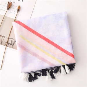 Detail of thin beach shawl with colorful stripes and multi-colored fringe tassels