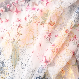 Detailed macro view of thin floral scarf fabric with elegant gold foil printed outlines