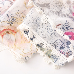 Close-up of floral scarf with gold outline print and white crochet lace border