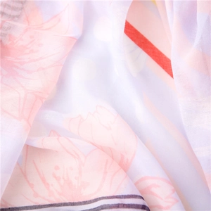 Macro detail of breathable white silk scarf with pink floral and purple dot patterns