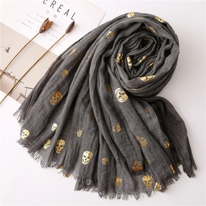 Detail of gold foil skull patterns on dark grey crinkle texture cotton linen scarf