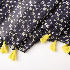 Detailed texture of navy blue floral cotton scarf with bright yellow fringe tassels