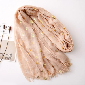 Detail of peach scarf with gold foil skull prints and soft fringe decorative edges