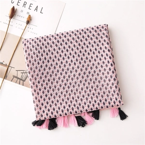 Detail of pink cotton-linen scarf with black geometric diamonds and fringe tassels