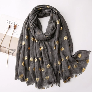 Detail of dark grey scarf featuring gold foil elephant prints and delicate fringed edges