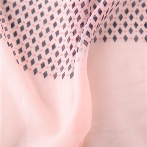 Detail of light pink cotton linen scarf with geometric diamond pattern and soft texture