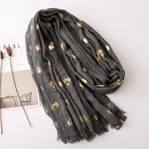 Detail of dark grey scarf with golden elephant print and delicate fringe edges