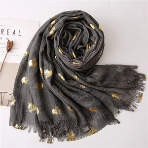 Detailed shot of dark grey scarf featuring gold foil elephant prints and fringe edges