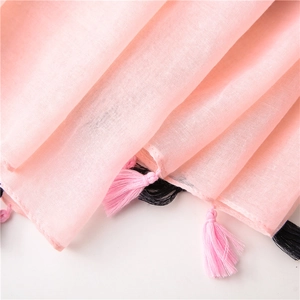 Close-up of light pink scarf with delicate geometric black and pink fringe tassels